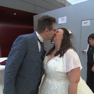 Küssendes Paar in Anzug und Brautkleid