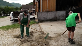 Auf dem Sulzburghof in Lenningen fegen Uropa und Urenkel gemeinsam den Hof.