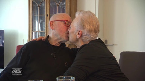 Ein älteres Paar küsst sich