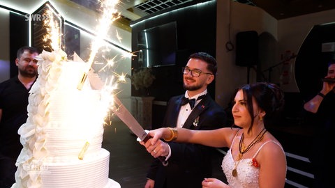 Brautpaar schneidet Hochzeitstorte an