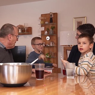 eine Familie sitzt am Tisch