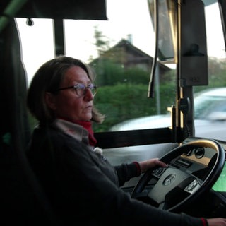 Melanie Schultz arbeitet als Bus- und Straßenbahnfahrerin in Freiburg. Sie sitzt am Steuer eines Busses.