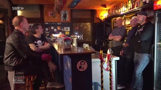 5 Männer sind in einer Kneipe an der Theke zu sehen