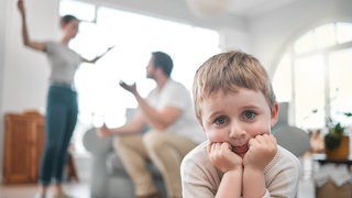 Ein Kind guckt traurig während die Eltern sich streiten | Psychologin Katharina Grünewald über die Auswirkungen von Trennung und Scheidung auf Kinder