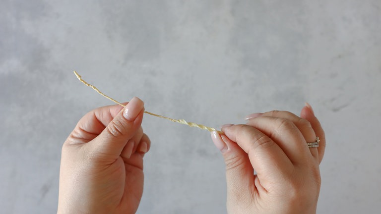 Jetzt den kleinen gelben Streifen (ca. 10 cm lang und 0,5 cm breit) ausformen und einrollen 