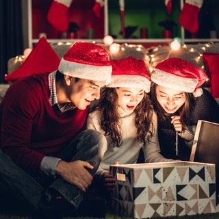 Familie beim Auspacken eines Weihnachtsgeschenks