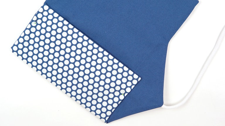 Die untere Klappe der Bestecktasche markierungsgemäß nach oben falten und bügeln. 