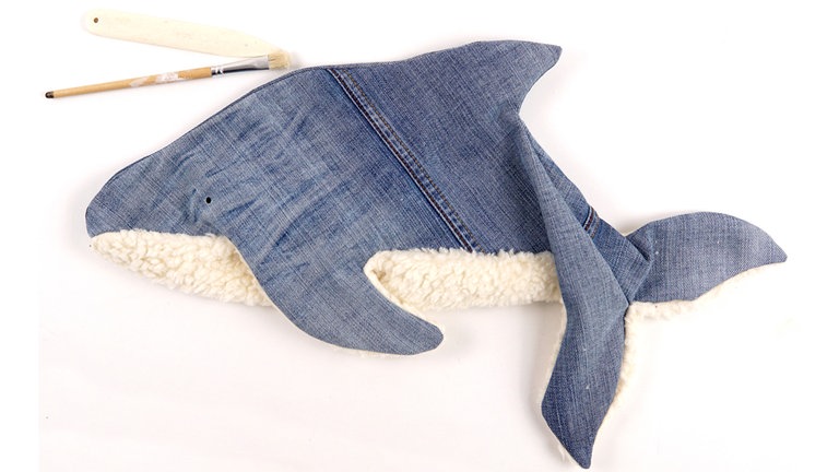 Den Delfin auf rechts wenden und alle Rundungen mithilfe eines stumpfen Gegenstandes (z.B. Stiftende, Pinselende, dicke Stricknadel) sorgfältig ausformen. 