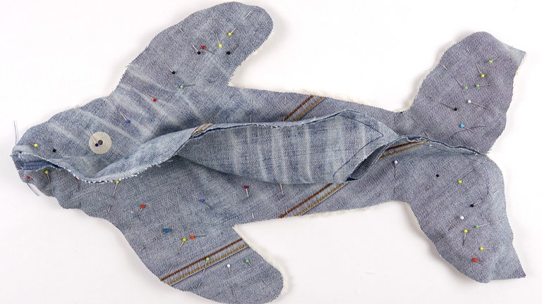 Den Körper rechts auf rechts auf das Bauchteil legen und feststecken. ((