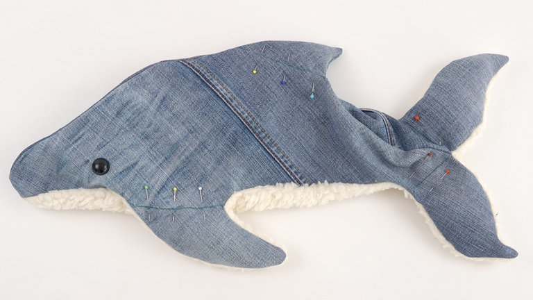 Anschließend die Stofflagen an den Steppnähten (siehe Markierung im Schnitt) aufeinanderheften. Dafür die Füllwatte etwas weiter in die Teile schieben, damit die Stofflagen glatt aufeinanderliegen. 