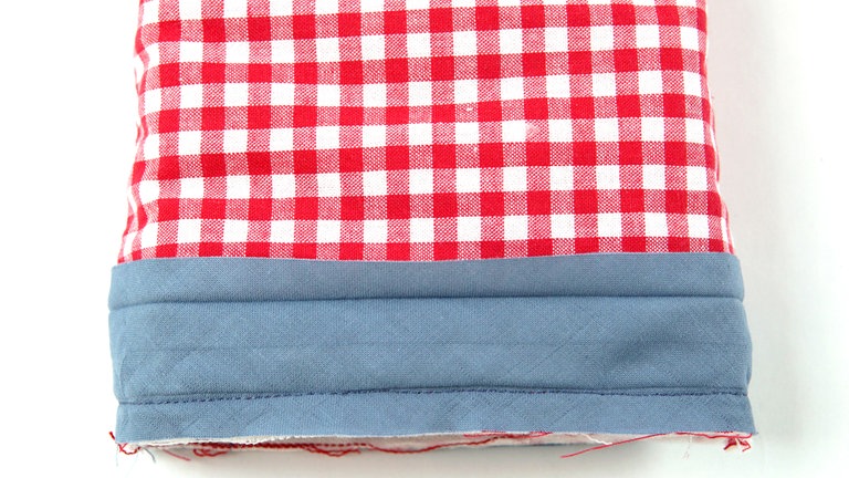 Das Schrägband 1 mm rechts von der ersten Umbruchkante feststeppen.