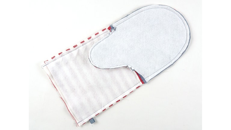 Die Innenseite aus Oberstoff (+ Thermolam) rechts auf rechts auf die Außenseite aus Oberstoff (+ Thermolam) legen.. Die Stofflagen an den Seitenkanten und der oberen Handschuhkante aufeinanderheften und zusammennähen.