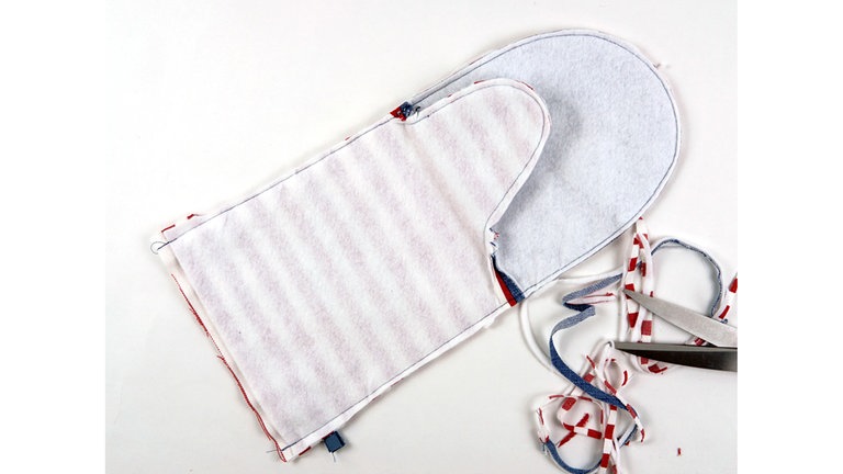 Die Nahtzugaben an den Rundungen auf 5 mm zurückschneiden, an der Unterkante jeweils 2 cm der Nahtzugabe stehen lassen.