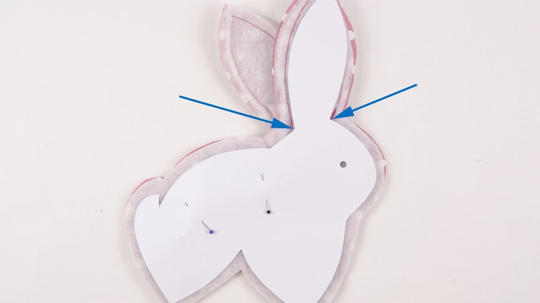 Die vordere Naht und die Rückennaht schließen. Dafür den Nahtverlauf mit Hilfe eines Körper Schnittteils auf dem Volumenvlies anzeichnen oder ein Körper Schnittteil als Schablone aufheften und daran entlang nähen.