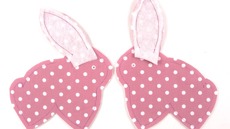 Die Ohren auf die Körperteile steppen, Nahtbeginn und –ende mit Rückstichen sichern. 