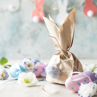 Osterdekoration mit Eiern, Blumen und Papierosterhase