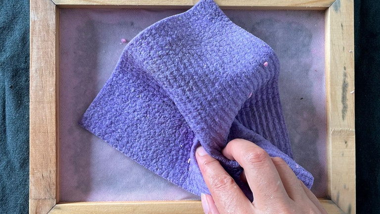 Das Papier mit Tüchern beschweren und die restliche Flüssigkeit ausdrücken. 