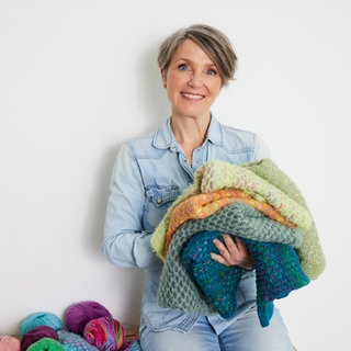 Tanja Steinbach mit verschiedenen gestrickten Sachen auf dem Arm