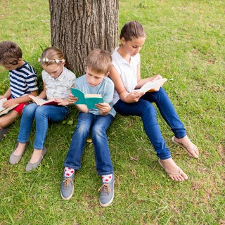 Kinder lesen im Park