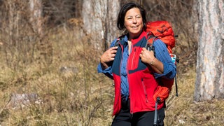 Wanderin mit Wanderhose, Wanderhemd, Wanderweste und Rucksack