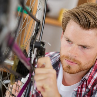 Schneller Fahrradcheck im Frühling - Mann repariert Fahrrad