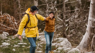 Paar wandert in den Bergen und hat Funktionskleidung an