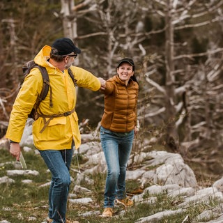 Paar wandert in den Bergen und hat Funktionskleidung an