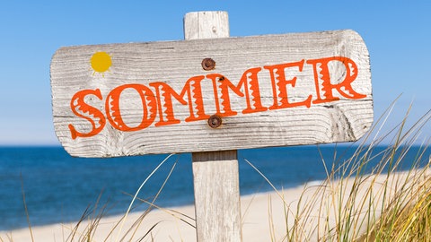 Schild am Strand mit Aufschrift Sommer