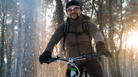 Mann fährt im Winter Fahrrad