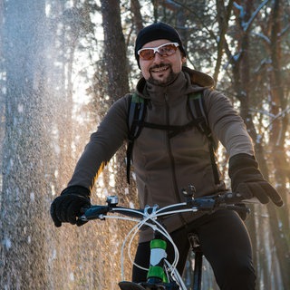 Mann fährt im Winter Fahrrad
