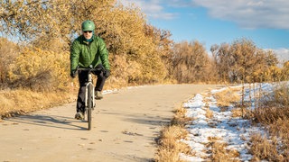 Mann fährt im Winter Fahrrad