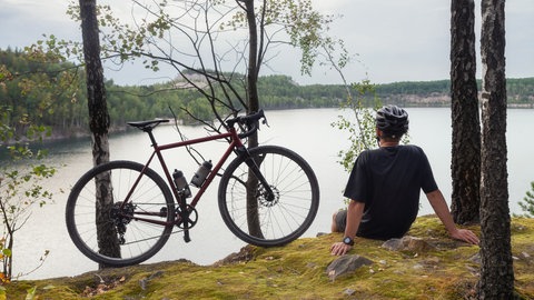 Mann mit Fahrrad am See - Radtour 