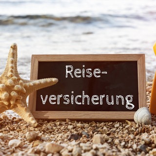 Schild mit Reiseversicherung - Schutz im Urlaub und Ausland