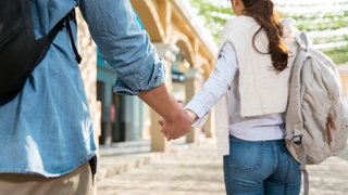 Junges Paar mit Rucksack - modisch für die Stadt