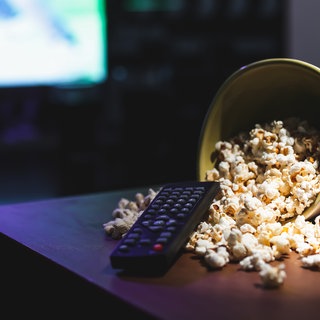 Popcorn und Fernbedienung auf einem Tisch