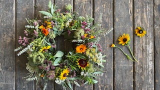 Zum Schluss verschiedene Blüten, wie z.B. Ringelblume, Sonnenhut in den Kranz stecken.
