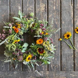 Zum Schluss verschiedene Blüten, wie z.B. Ringelblume, Sonnenhut in den Kranz stecken.