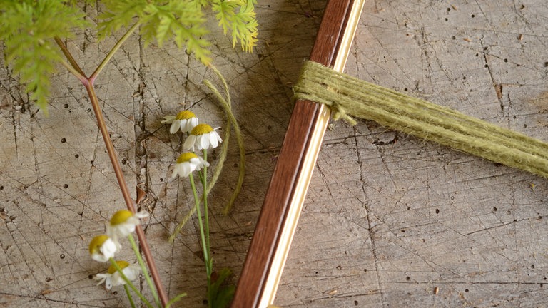 Das Schnurende am Rahmen verknoten.