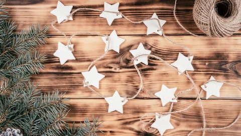 Weihnachtliche Sterne aus Salzteig an Reisig gehängt: Solche Deko lässt sich aus dem Teig nachdem Trocknen und Bemalen herstellen.