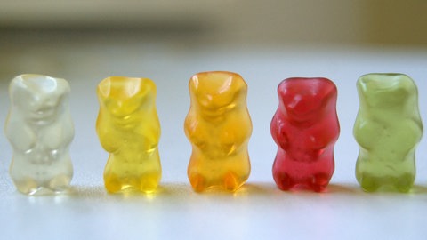 Anstelle von Bleigießen an Silvester das Gummibärchen Orakel - fünf Gummibärchen stehen nebeneinander mit Gesicht nach vorne in den Farben weiß, gelb, orange, rot und grün von links nach rechts