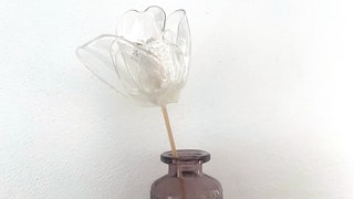 Dann die vier kleineren Blütenblätter um das Innere der Blüte festkleben. Zum Schluss die vier größeren Blütenblätter versetzt zu den inneren Blütenblättern festkleben. 