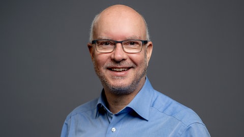 Porträt des SWR4 Experten Andreas Reinhardt im hellblauen Hemd