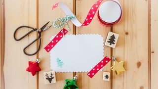 Schere, Papier und Stempel: Damit lassen sich hübsche Weihnachtskarten basteln.