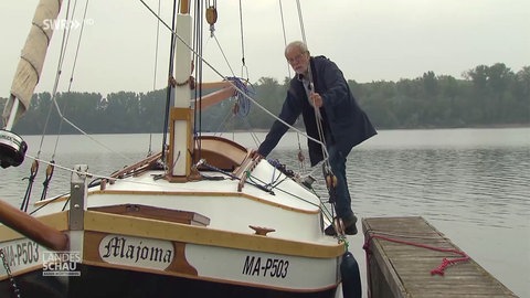 Mann steht auf seinem Boot