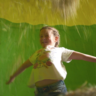 Mädchen spielt mit Heu