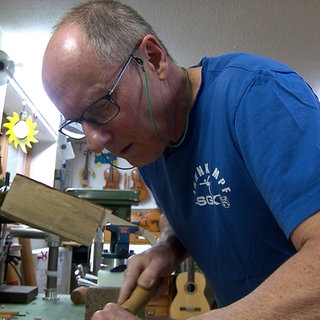 Rainer Heldner baut in seiner Freizeit Instrumente. Er steht ins einer Werkstatt in Heidelberg.