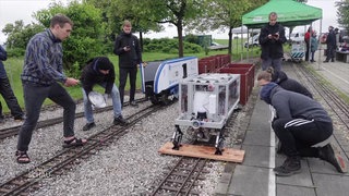 Mehrere Personen testen ihre selbstgebaute Lok