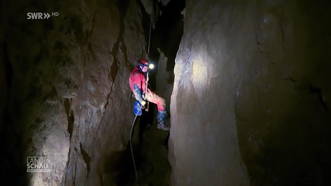 Ein Höhlenretter seilt sich ab