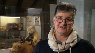 Jeanette Zenko aus Remseck steht vor Vitrinen im Stadtmuseum Ebersbach. Im HIntergrund sind Teddybären zu sehen.