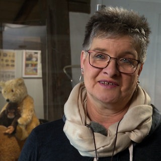 Jeanette Zenko aus Remseck steht vor Vitrinen im Stadtmuseum Ebersbach. Im HIntergrund sind Teddybären zu sehen.